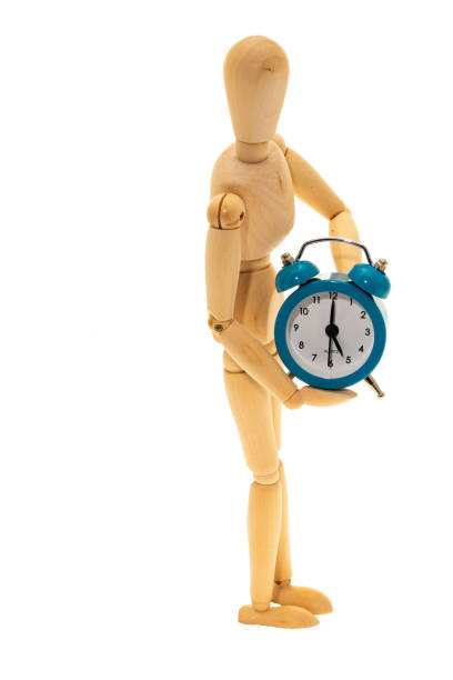istock Mannequin figure holding an alarm clock 1169022702