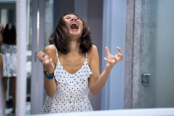 mujer enojada gritando al espejo y llorando - furioso fotografías e imágenes de stock