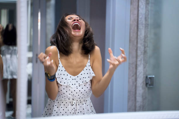 angry woman shouting at mirror and crying - furious imagens e fotografias de stock