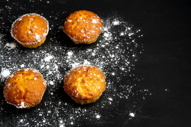 istock Appetizing muffins stand on a table top view. Traditional pastries on a dark background minimalism. 1169025272