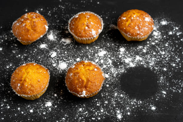 istock Appetizing muffins stand on a table top view. Traditional pastries on a dark background minimalism. 1169025280