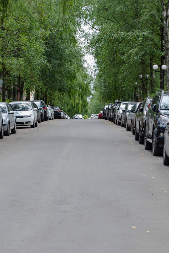 A road with tightly parked cars on both sides.
