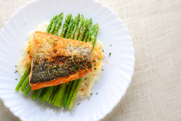 istock Grilled salmon garnished with asparagus and herbs and mashed potatoes, served on white plated.