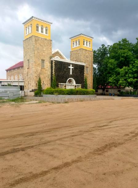Juba, South Sudan: stone covered facade and bell towers of the All Saints Anglican Cathedral - Anglican Diocese of Juba - stormy sky - located at the Mobil Roundabout