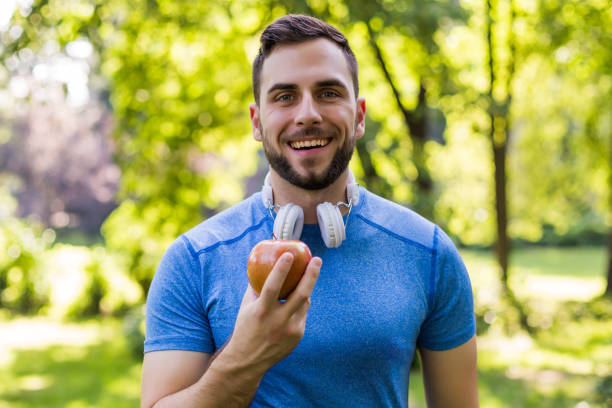 Sporty man eating apple