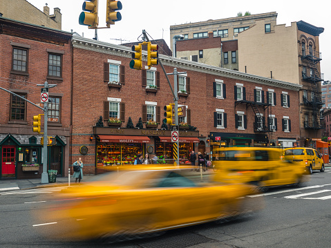 New York City, USA - May 03, 2019: Blurred yellow taxi cabs speeding on the 8th Avenue in Manhattan