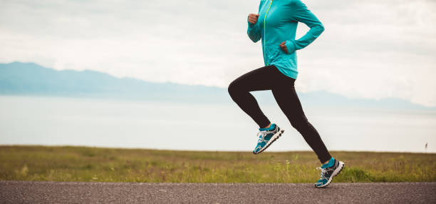 jeune coureur sportif de femme de forme physique d'ultramarathon fonctionnant sur la route - cross coat photos et images de collection