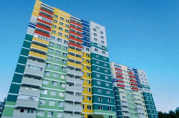 Photo of Colored facade wall of a modern residential building with a view from the bottom up against the sky.