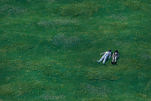 Astronauts lying in the meadow. This is entirely 3D generated image.
