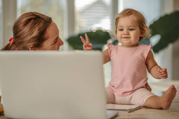istock Cheerful baby helping her mother work on a laptop 1169041323