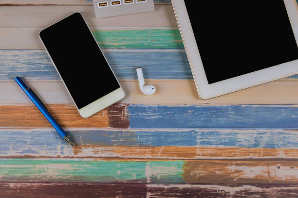 istock Tablet, phone, wireless headphones and pen on the table. 1169048687