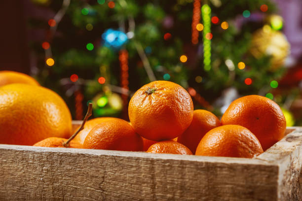 istock Mandarins in wooden box with christmas tree. 1169048719