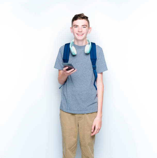 istock Young 13 year old boy standing in front of white wall 1169056214