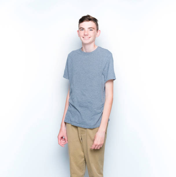 istock Young 13 year old boy standing in front of white wall 1169056343