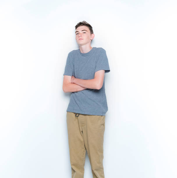 istock Young 13 year old boy standing in front of white wall 1169056367