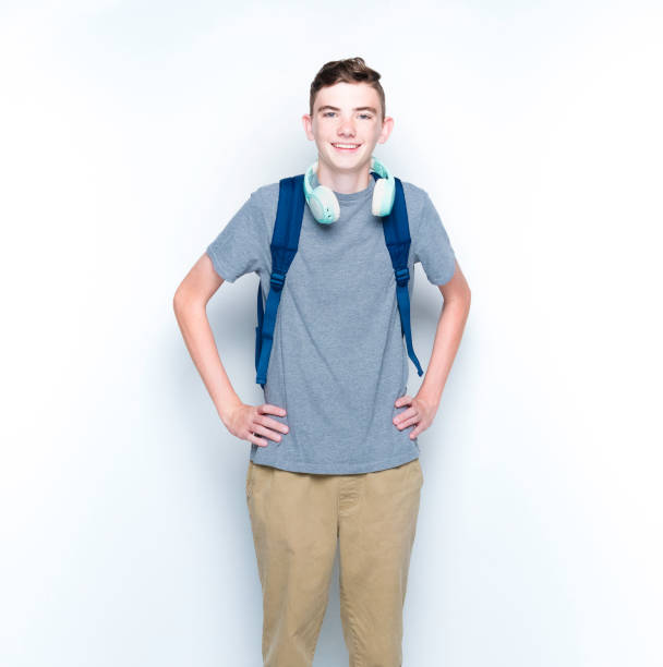 istock Young 13 year old boy standing in front of white wall 1169056460