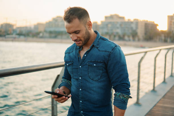 istock A young handsome man on the bridge near beautiful beach. 1169057579