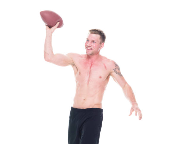 istock Handsome shirtless man holding a football 1169060331