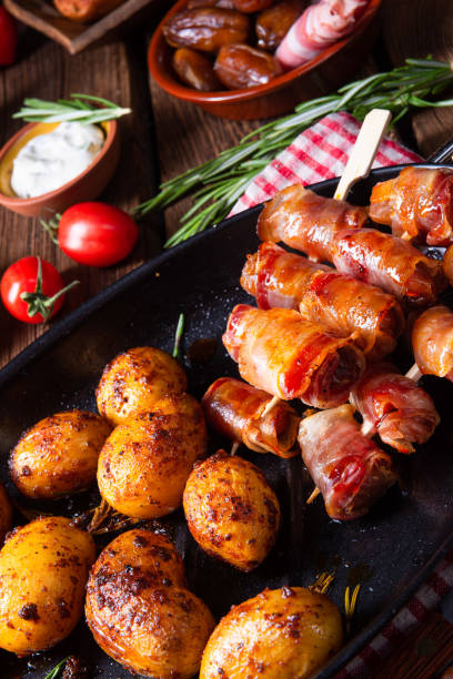 istock Rustic dates wrapped in bacon and young roasted potato. 1169061480