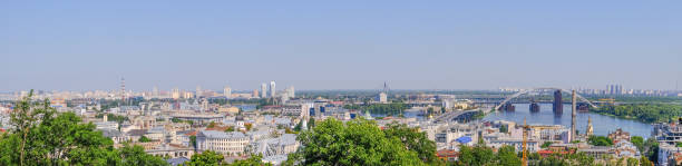 City landscape view of the Dnieper in Kiev City landscape panoramic view of the embankment from the right bank of the Dnieper in Kiev, Ukraine, 08/19/2019 district of the river station, Podil and the bridge under construction, sunny day panoramic riverbank architecture construction site stock pictures, royalty-free photos & images