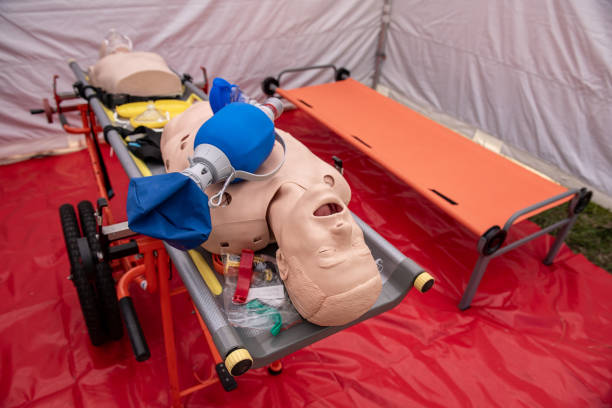 CPR Airway Management Training medical procedure AED and bag mask valve , Demonstrating chest compressions on CPR doll in Mobile Hospital stock photo
