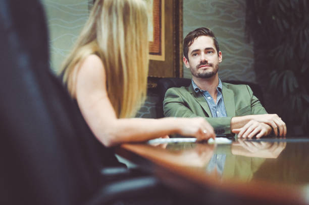 istock Busi ess people sitting at a conference table smiling and having a meeting 1169070521