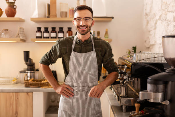 istock Cheerful barista smiling while welcoming guests 1169071786