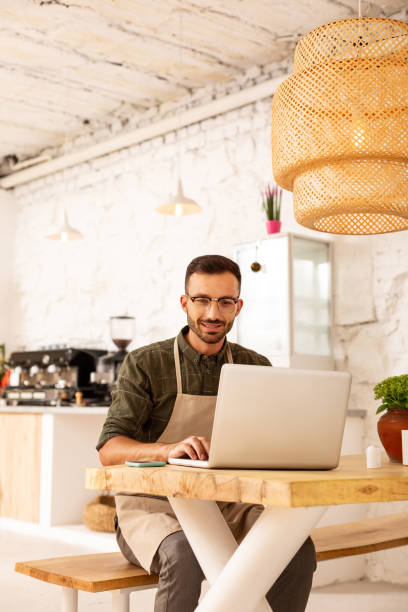 istock Entrepreneur sitting in his cafeteria and working on laptop 1169071818