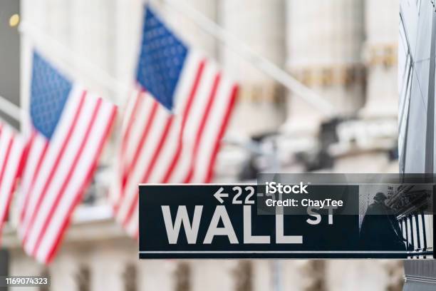 Wall Street Sign In New York City Financial Economy And Business District With America National Flag Background Stock Market Trade And Exchange Zone Stock Photo - Download Image Now