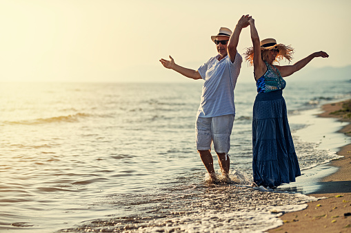 Senior couple enjoying summer vacations. The couple is dancing on the beach on sunset.
Nikon D850