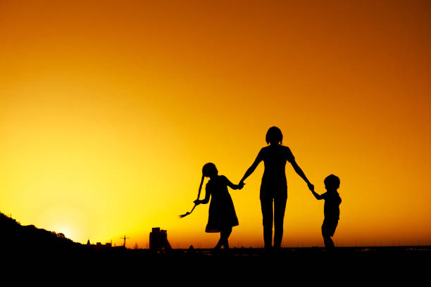 istock Mother with two children are dancing at Sunset 1169075547