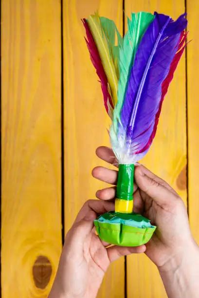 Photo of Children's Day. Female hand holding shuttlecock with colorful feathers. Copy space, graphic resource