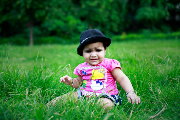 A young girl wearing pink clothes and a blue headscarf