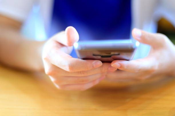 The hand of a girl looking at her smartphone Defocused