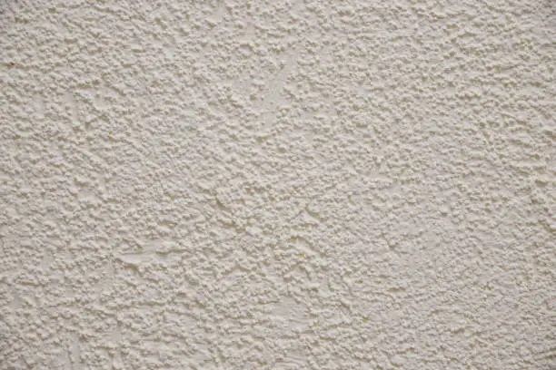 Photo of Texture of the old plastered beige color cement wall, Surface emboss sharp and rough pattern of concrete wallpaper background.beige embossed background. concrete wall