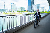 environmental friendly way to work, commuter on bike in office district