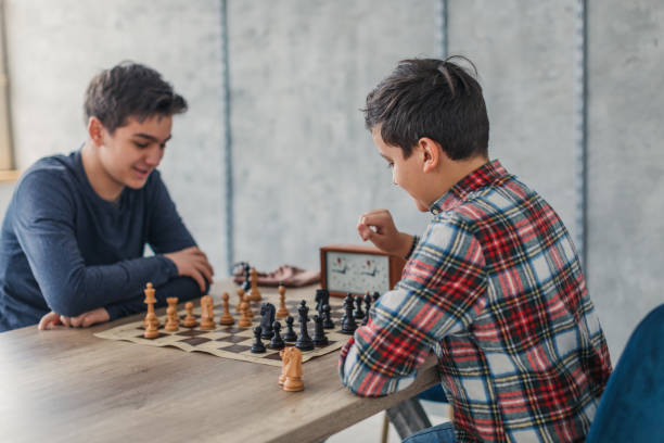 istock Smart boys playing chess in school of chess 1169091559
