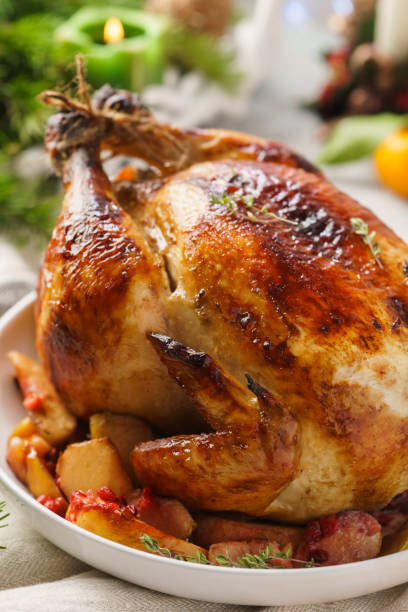 istock Traditional Christmas whole chicken or turkey with apples. 1169092807