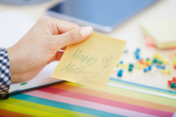 istock Human hand holding adhesive note with Happy mothers day text 1169093309