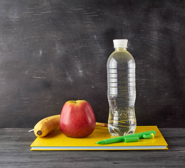 istock red ripe apple, yellow banana  on a yellow closed notebook 1169093904