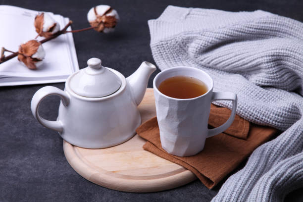 istock tea and teapot on cutting board, gray plaid 1169094086