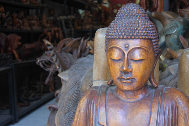 Wooden buddha statue in minimalist white background.