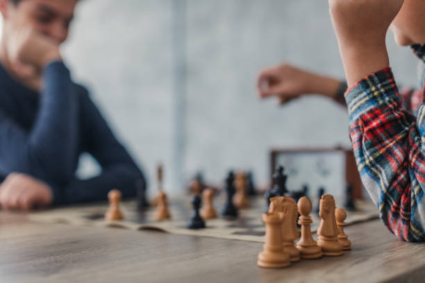 istock Two boys playing a game of chess 1169095100