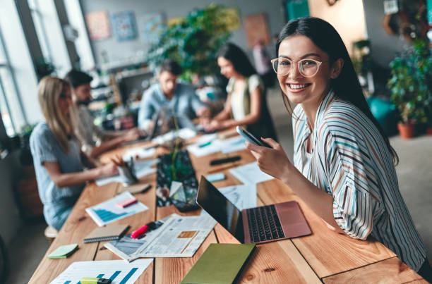 Business people working Group of young business people are working together in modern office. Creative people with laptop, tablet, smart phone, notebook. Successful hipster team in coworking. Freelancers. young adult stock pictures, royalty-free photos & images