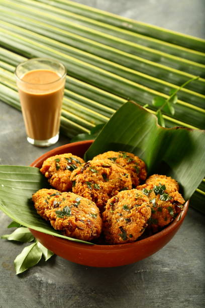 indian cuisine- healthy snacks- parippu vada and milk tea. - cooked vertical high angle view lentil imagens e fotografias de stock