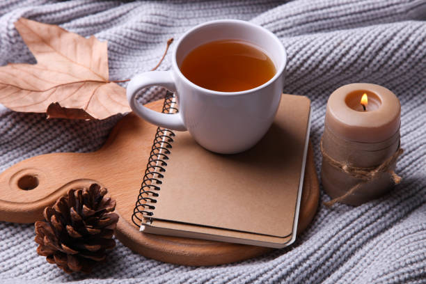 istock tea, notebook, candle and dry leaves 1169098659