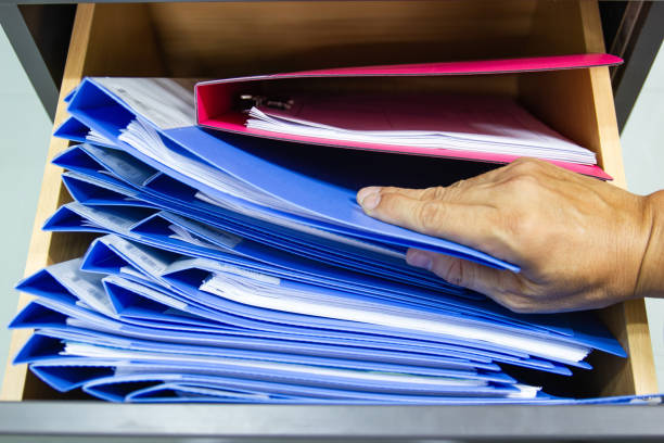 istock Hand of Man Search files document in a file cabinet in work office 1169101276