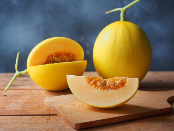 Fresh yellow melon fruit sliced. Fresh yellow melon fruit sliced with seed on wooden chopping board for a healthy eating concept. honeydew melon stock pictures, royalty-free photos & images