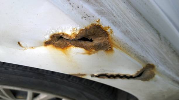istock White car with rust, corrosion, defects and scratches, close up. Surface rust repair concept. 1169102502
