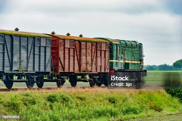 Old Diesel Freight Train Pulling Various Railroad Cars In The Countryside Stock Photo - Download Image Now